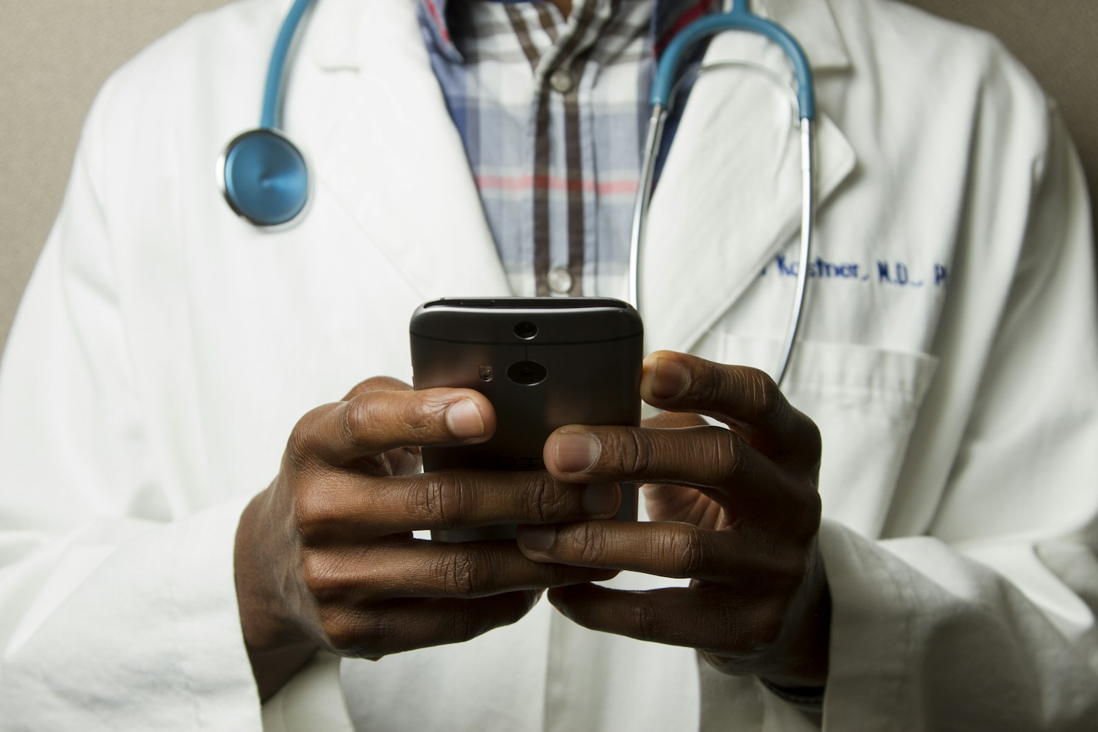 Healthcare worker reviewing communications on a phone — extending access to patients