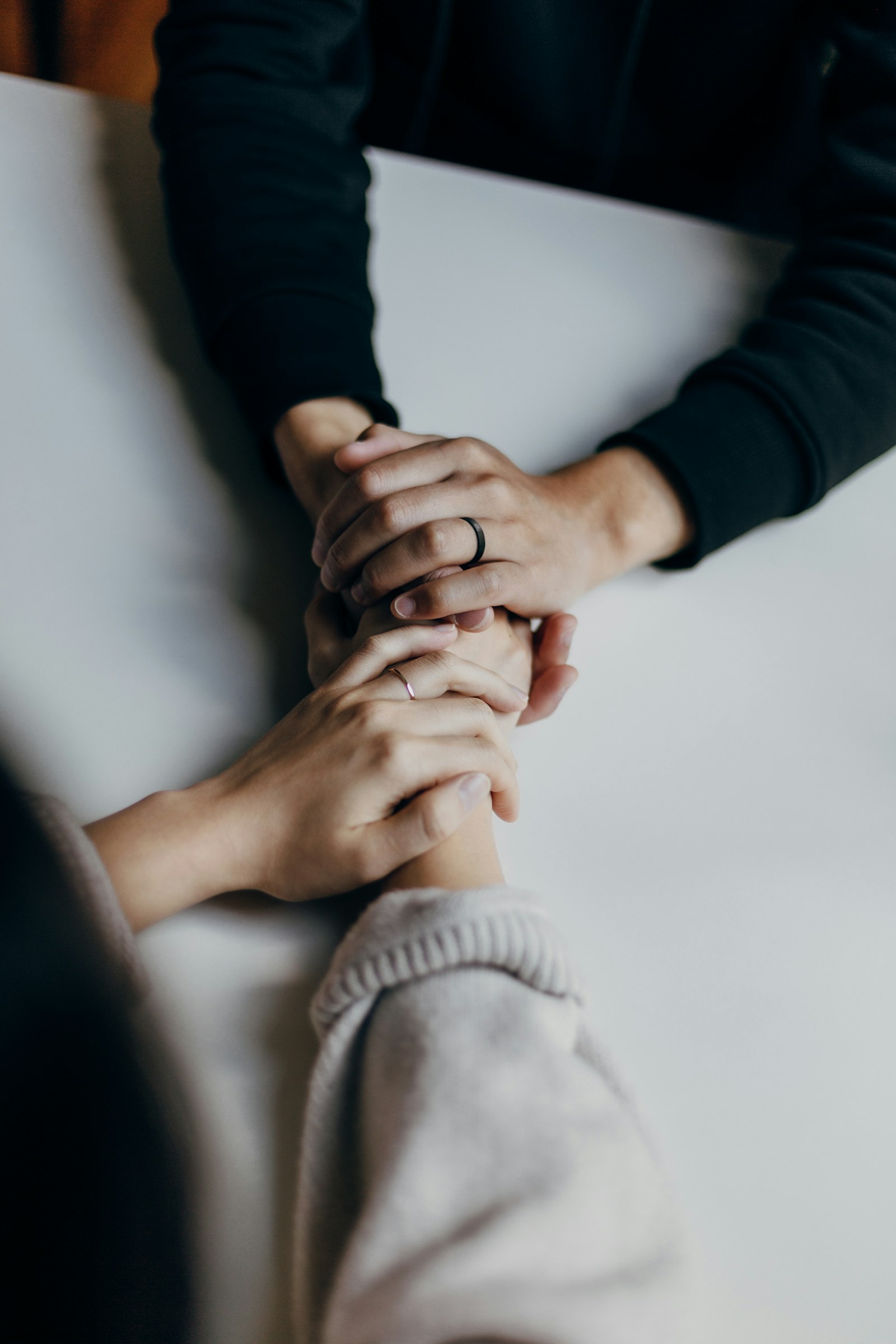 Two people clasping hands across a table — a partnership conversation